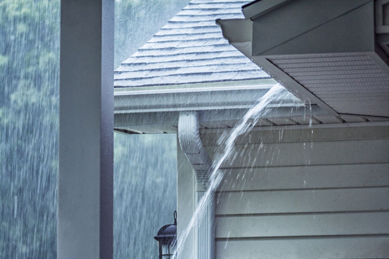 Home with Raining Storm Water Coming Out of Gutters