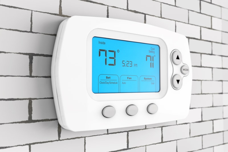Thermostat Settings: On vs. Auto. Modern Programming Thermostat in front of Brick Wall. 3d Rendering.