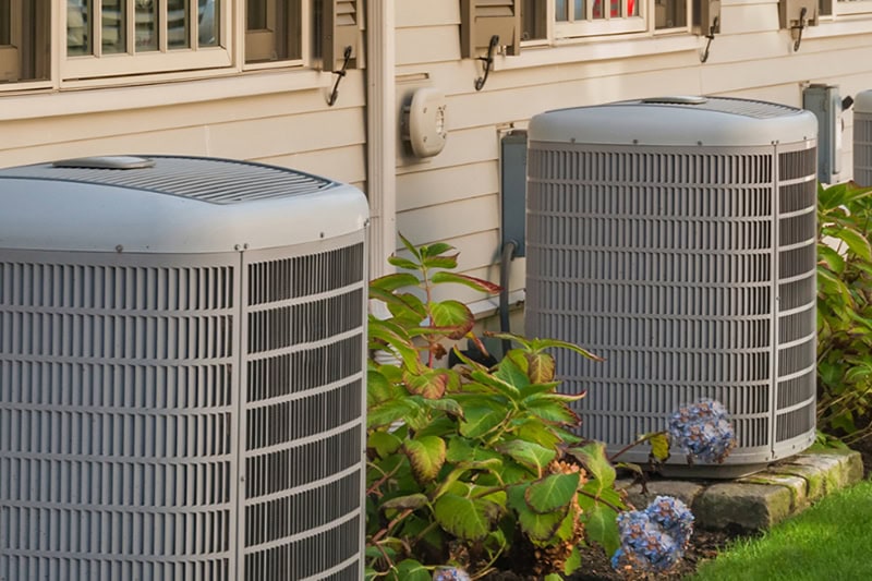 Spring AC Maintenance Tips. An air conditioner with flowers.