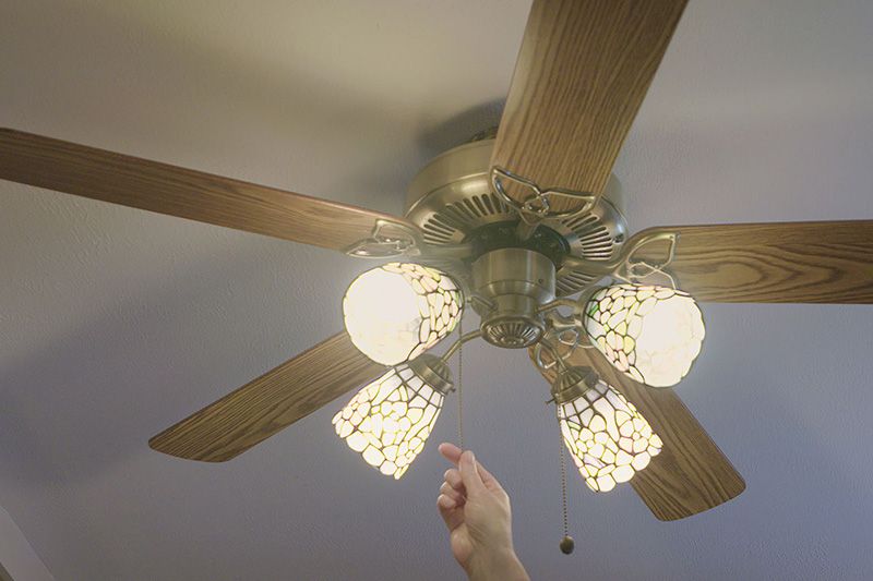 Video - Energy Saving Tip 2. Image is a photograph of a ceiling fan with four lit lights.